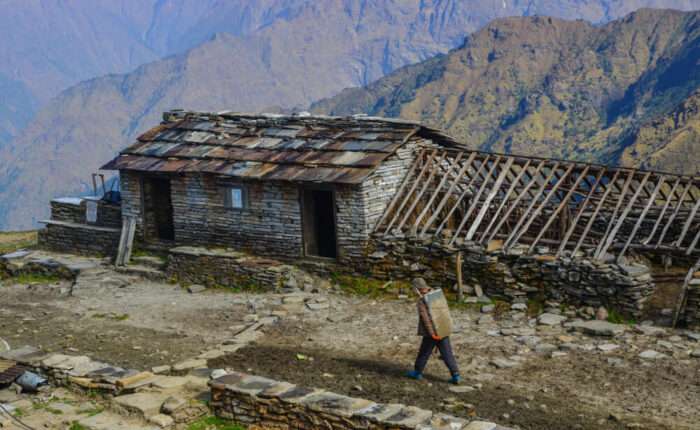 man-carrying-stones-mountain-village-khopra